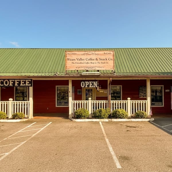 Wears Valley Coffee & Snack Co. building with a red exterior, green roof, and white picket fence.