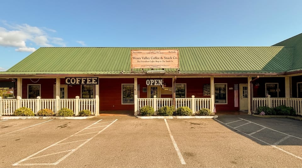 Wears Valley Coffee & Snack Co. building with a red exterior, green roof, and white picket fence.